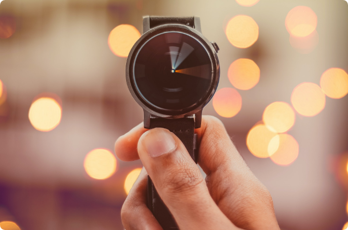 A person holding a watch and showing the amount of time that he or she was able to save because of Shizzle's marketing automation